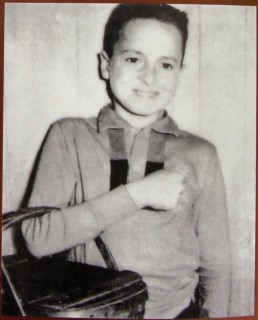 Young boy holding a lunch box.