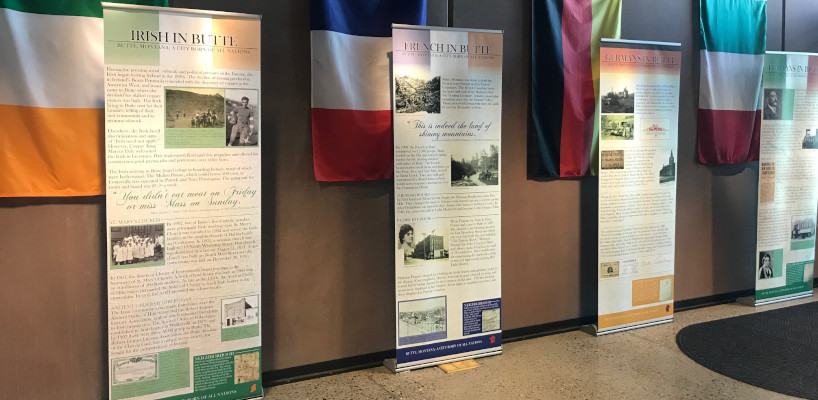Museum exhibit showing panels with photos and text of different national or ethnic identities